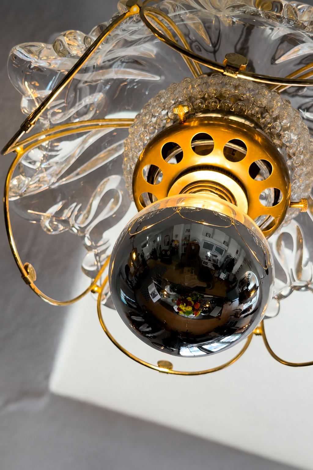 Close-up of sculptural glass shade and brass-toned fixture